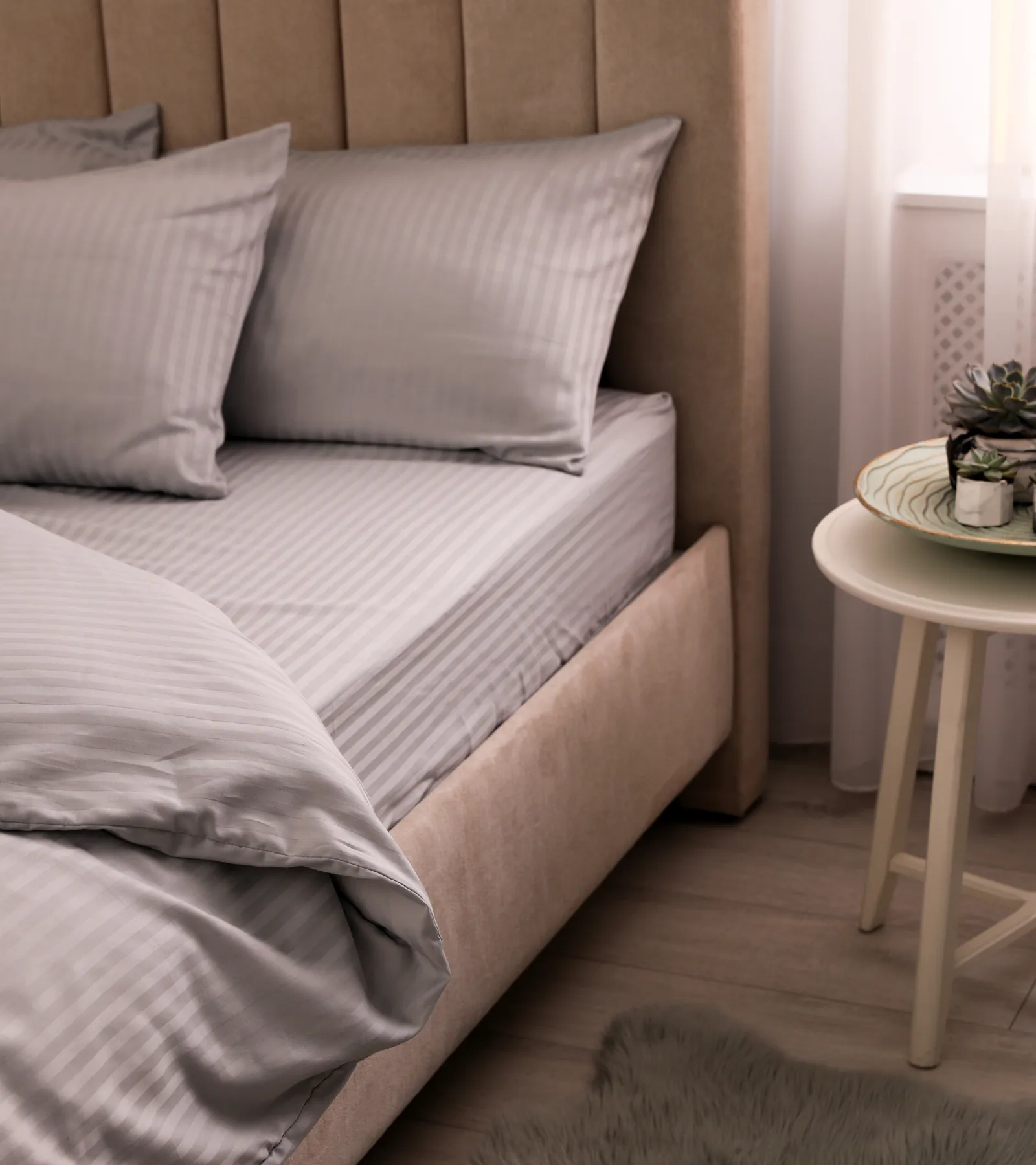 A softly layered bed in a bright, calm room